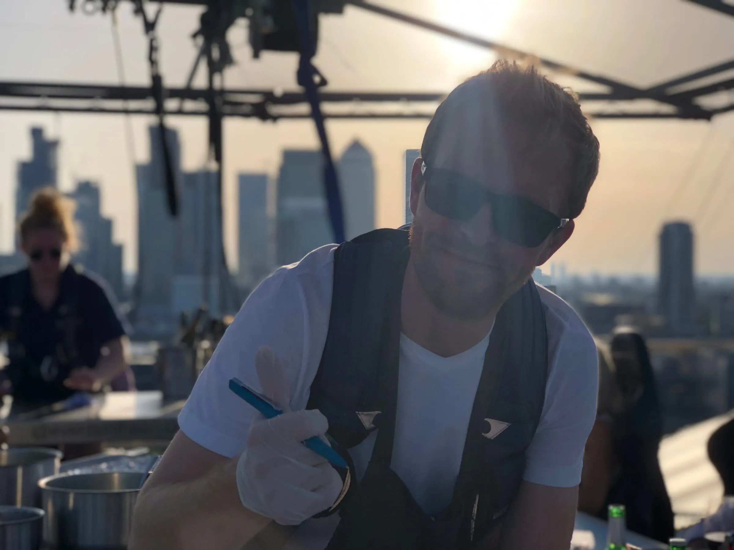 Jonathan McGlynn cooking at London in the Sky, with the Canary Wharf skyline behind